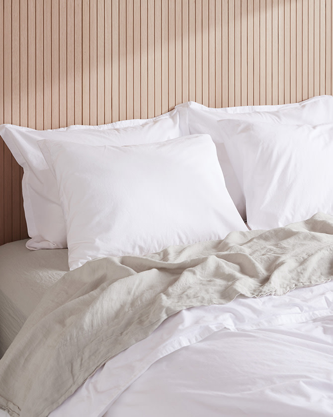 A bed with white percale sheets