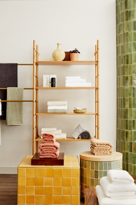Wooden shelves with neatly stacked towels in various warm tones