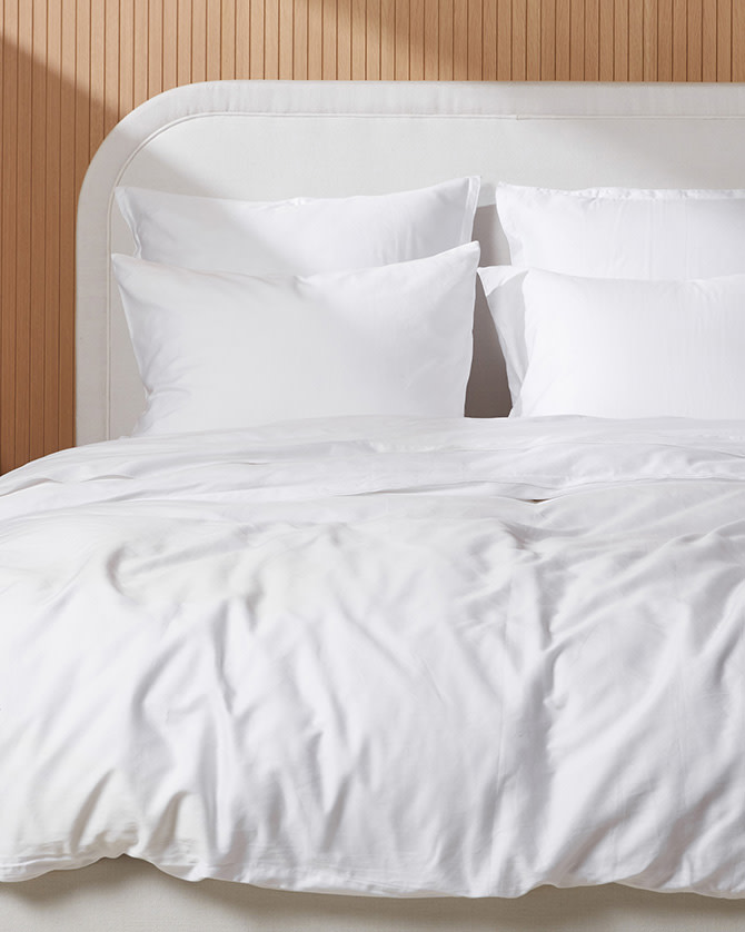 A neat bed with white sateen sheets