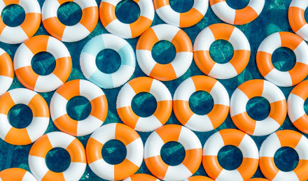 Photograph of orange and blue innertubes in a pool. 