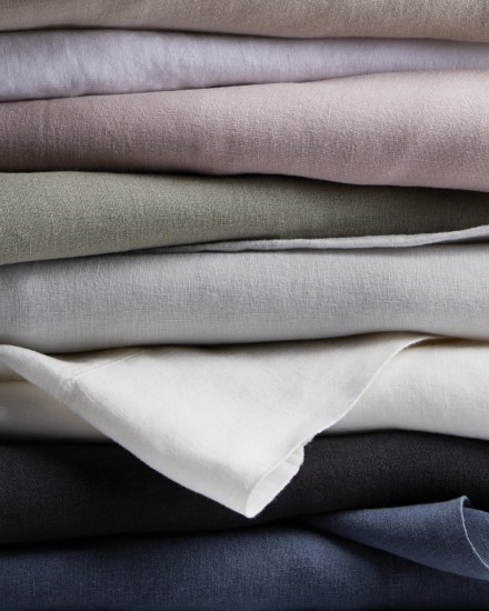 A stack of linen sheets in various colors