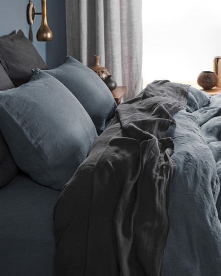 A messy bed with dusk and coal linen sheets