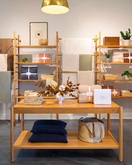 Shelves and tables filled with various quilts, comforters, and neatly packaged sheets