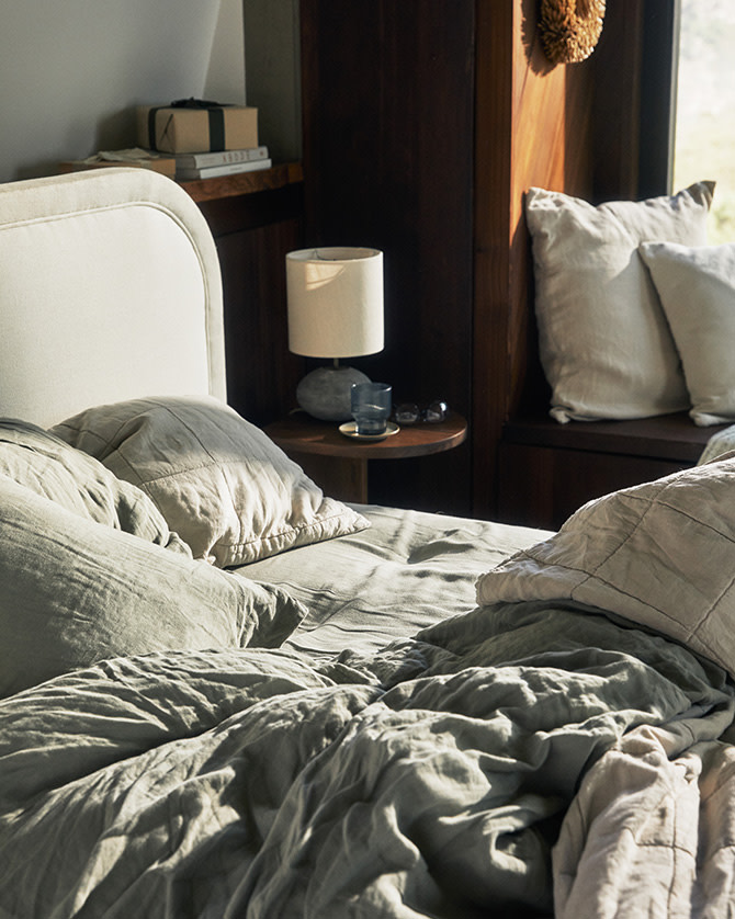 A messy bed with rumpled linen sheets