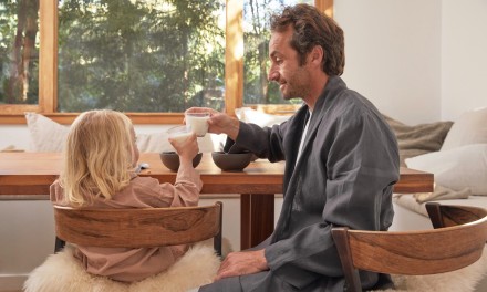 Dad and child eating breakfast together. 