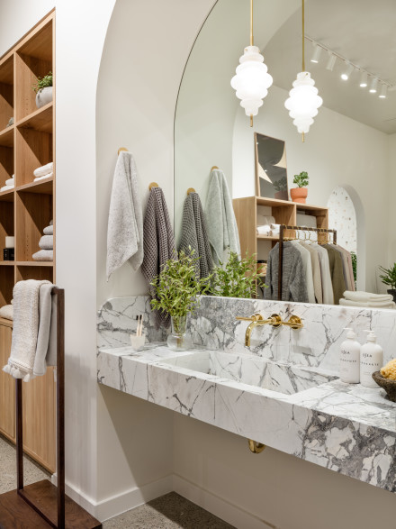 Marble sink and mirror with grey towels hung on the wall