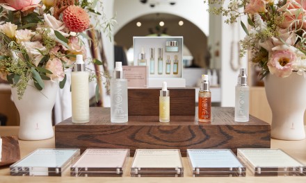 Anove Products display on a walnut platform between two vases of roses