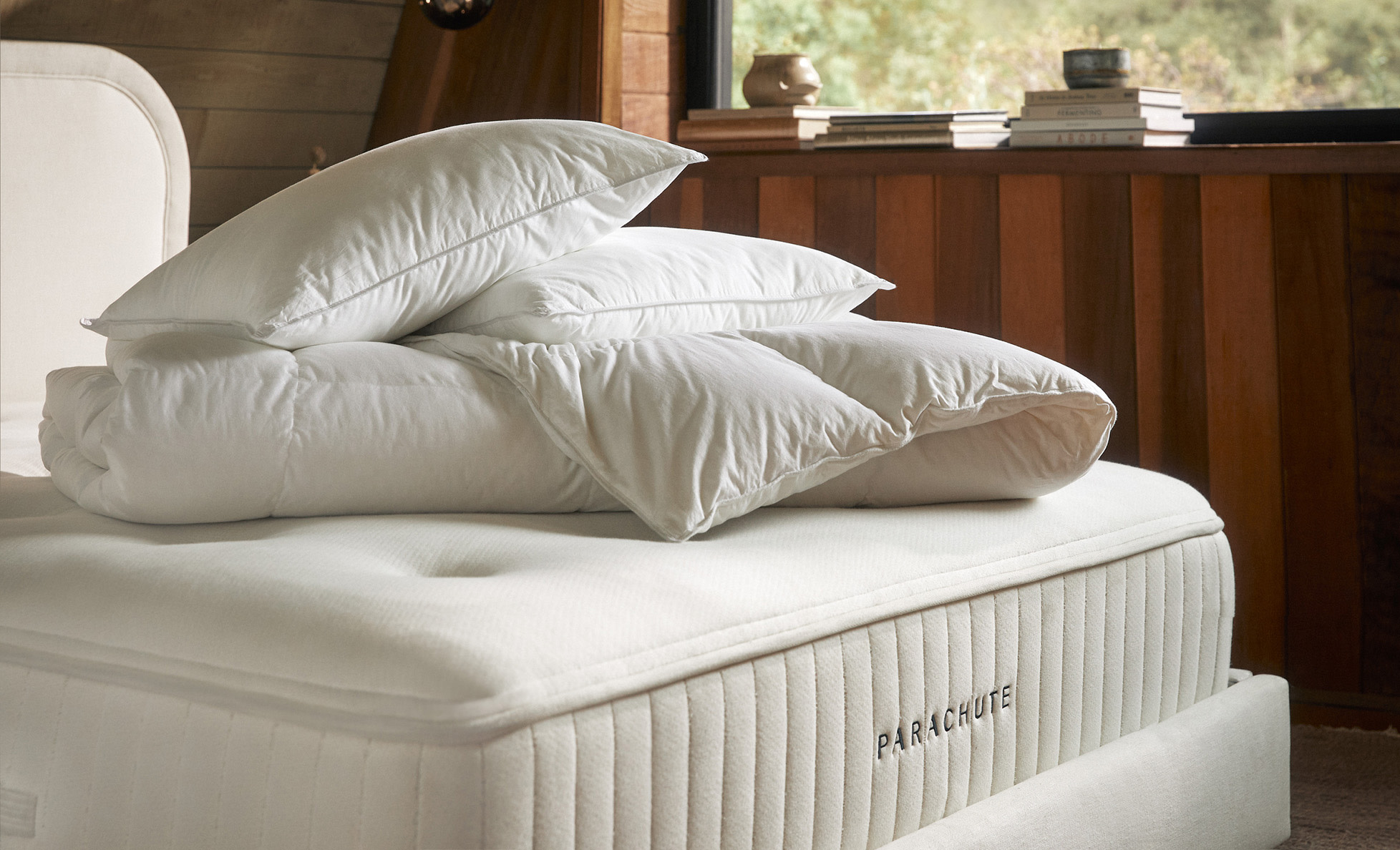 A bare mattress with pillow and duvet inserts stacked atop
