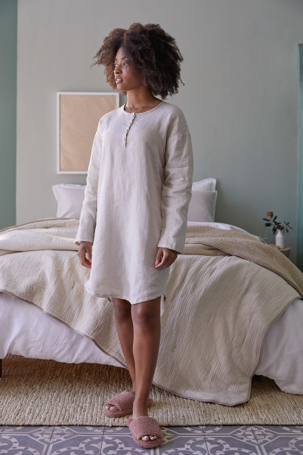 Woman standing in her room wearing a bone linen sleep shirt