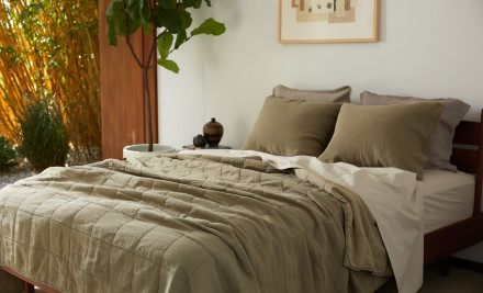 Bright bedroom with a messy made bed with surplus linen bedding