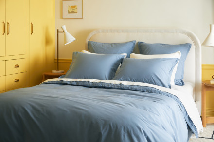 Side angle of bed dressed in wave percale sheeting