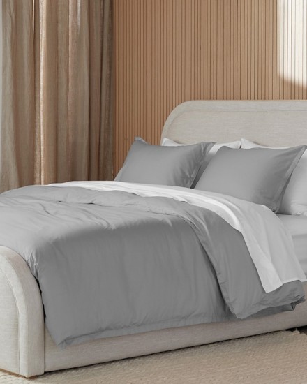 A neat bed with light grey and white sateen sheets
