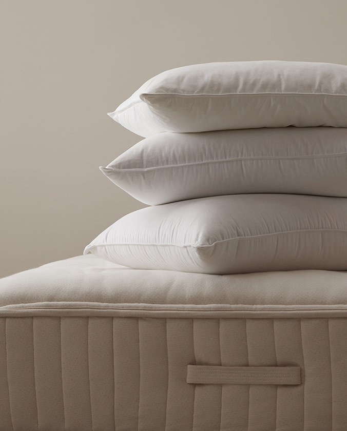 Three pillows atop a mattress.