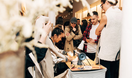 People gathered around a sewing machine 