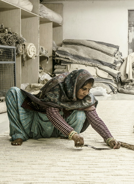 woman working on a rug 