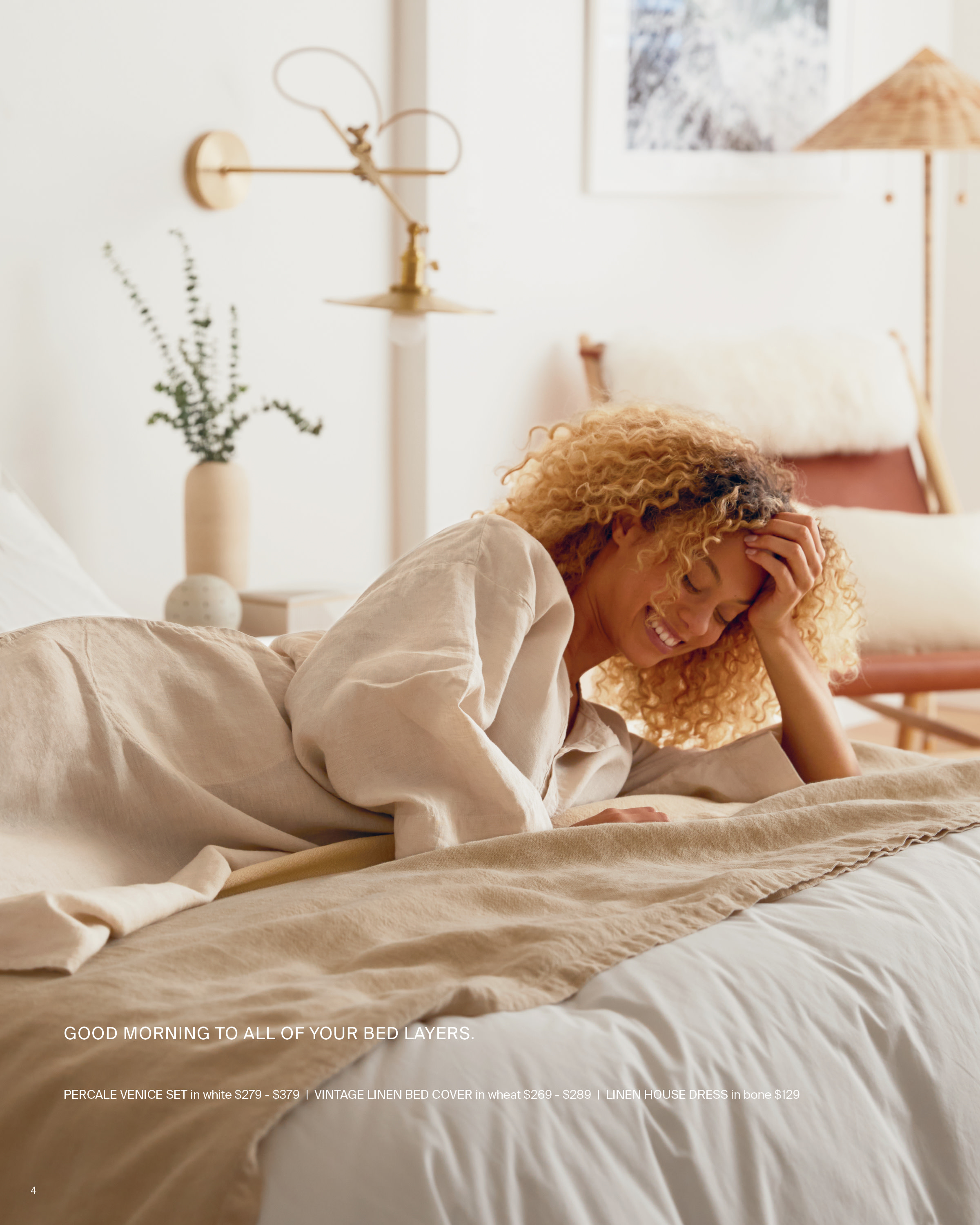 A woman laying on her side, laughing and enjoying linen bedding.