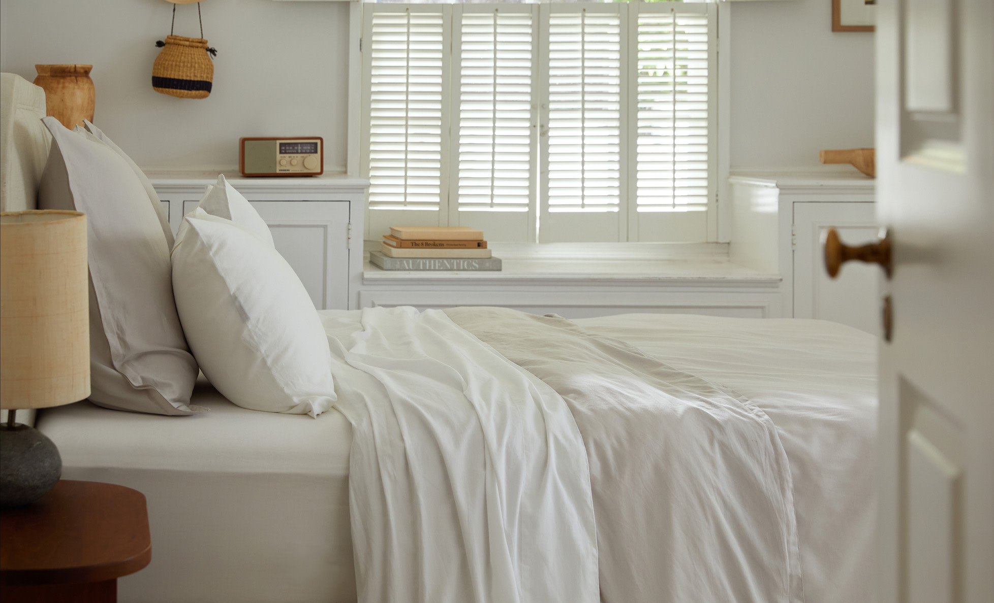 Side view of a bed with white sateen sheets
