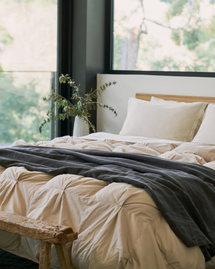 A bone organic cotton puff comforter on a bed