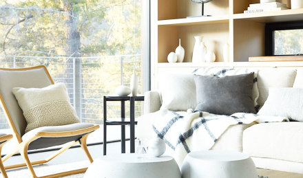 Image of a chair and sofa with clean pillows and blankets