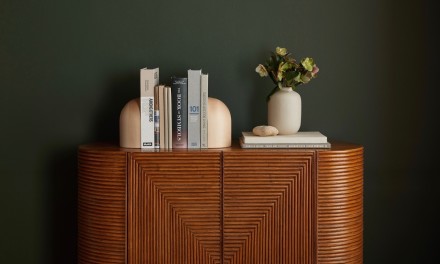 Books on credenza next to flowers. 