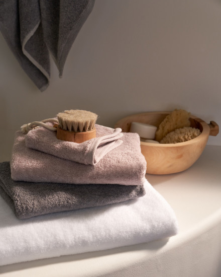 Three plush towels stacked on top of each other on a bathroom counter