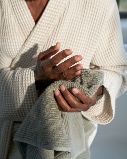 A person drying their hands with a moss soft rib towel