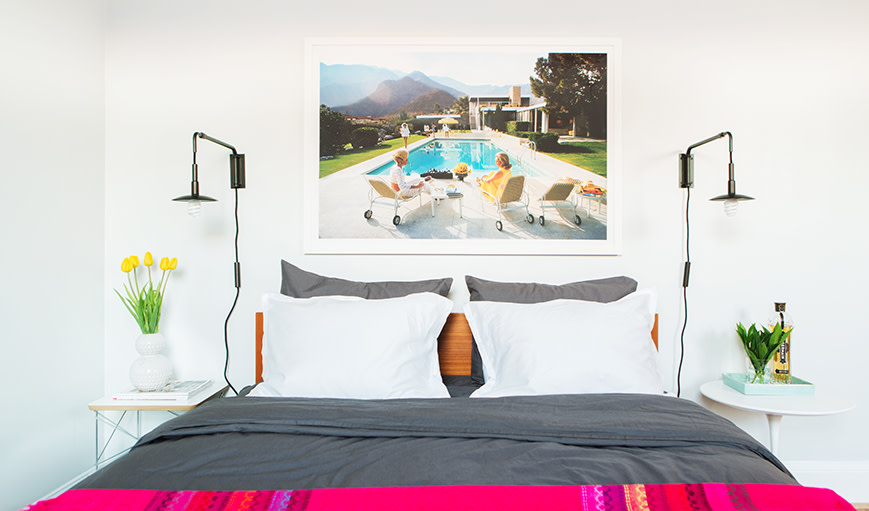 Bedroom with a statement art piece above the bed. 