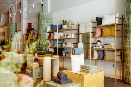 Wooden shelves filled with plush Parachute product in a brightly-lit showroom