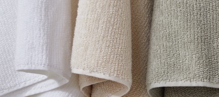 Three organic cotton towels hanging in a row