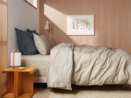 Side angle of a made bed featuring Latte bedding