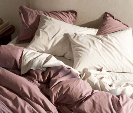 A messy bed with clover and white brushed cotton sheets