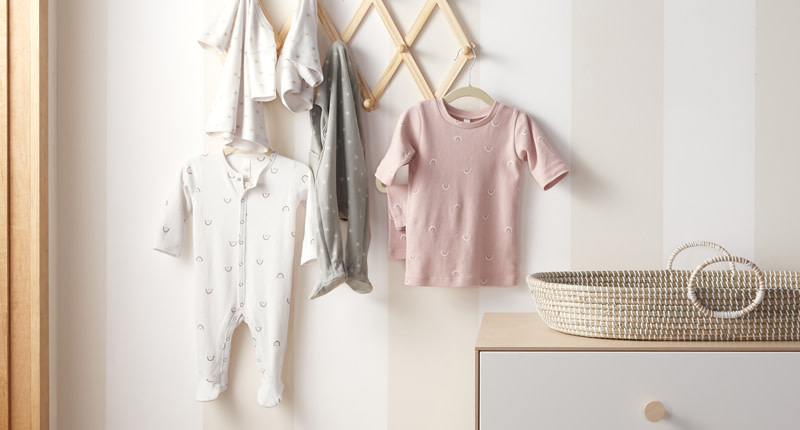 Collection of colorful baby and child pajamas hanging on a wall