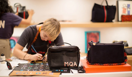 woman painting on a bag 