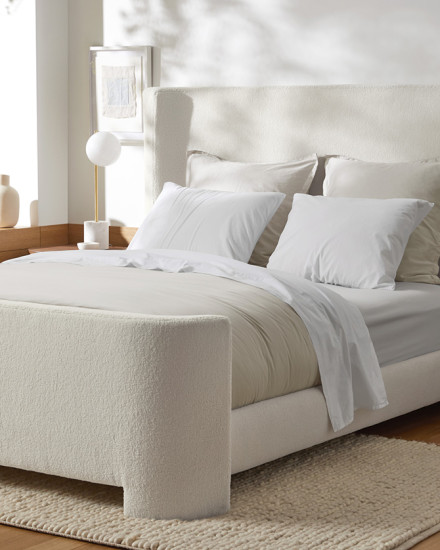 A neatly made bed with a plush bed frame
