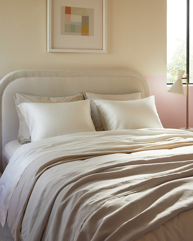 A minimalist bed with cream and white sateen sheets