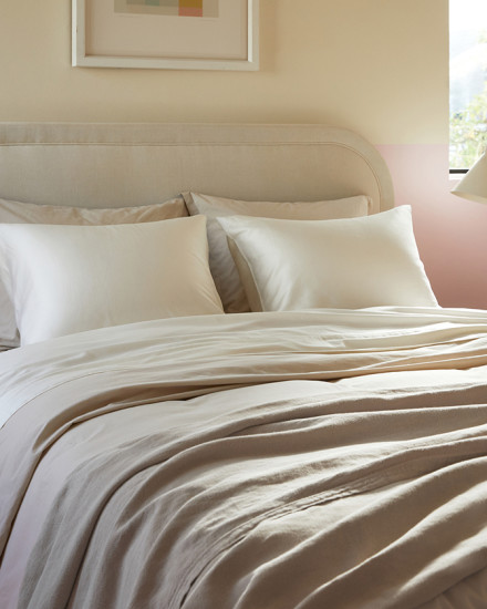 A neat bed with cream sateen sheets