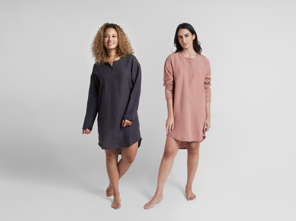 Two women modeling linen sleep shirts in front of a white background