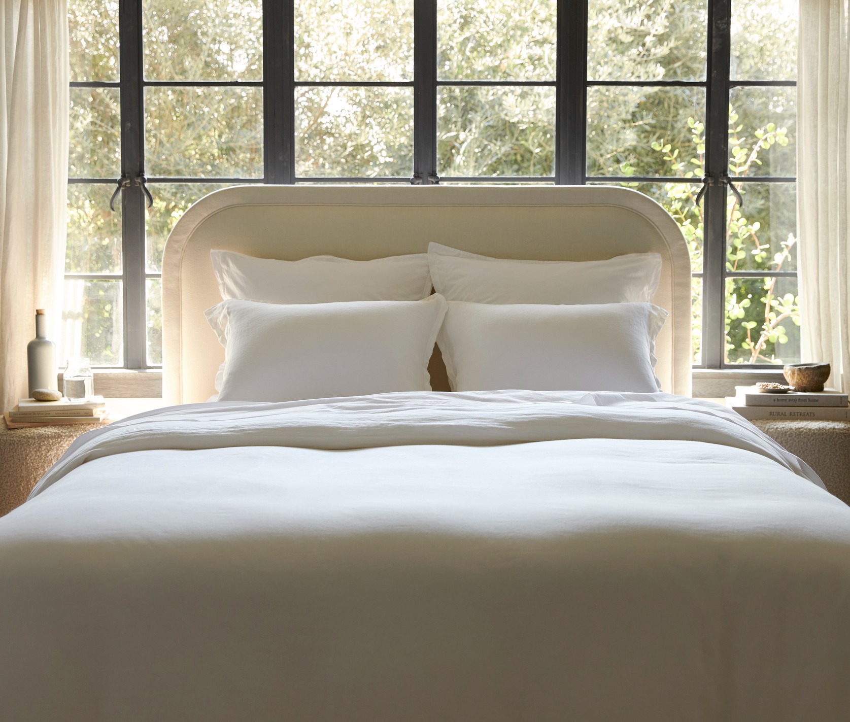 A bed with a moss green quilt and moss sheets