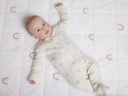 Rainbow Footie Pajama Shown In A Room