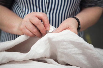 Image of Parachute employee prepping linen duvet cover