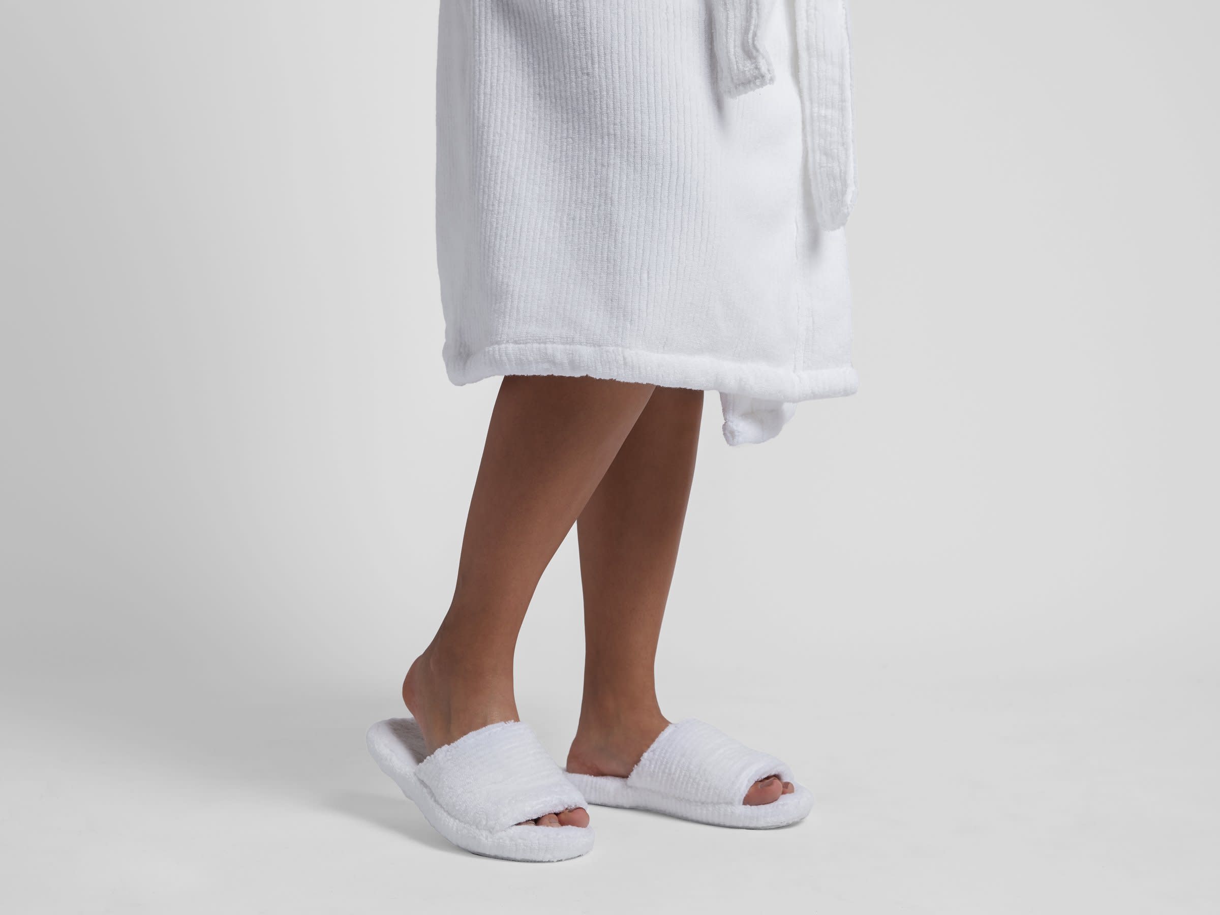 White Soft Rib Slippers Shown In A Room