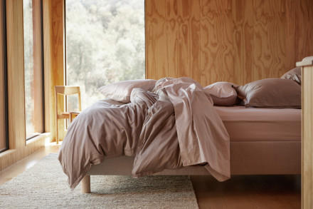 Side view of a messy bed with Blush sheeting