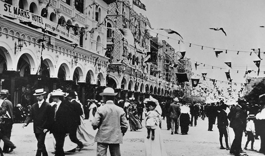 An old photograph of people walking in Venice. 
