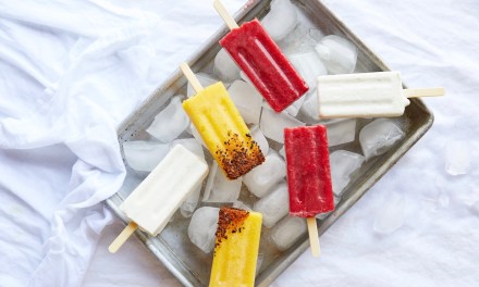 Mango, strawberry and coconut popsicles on ice. 