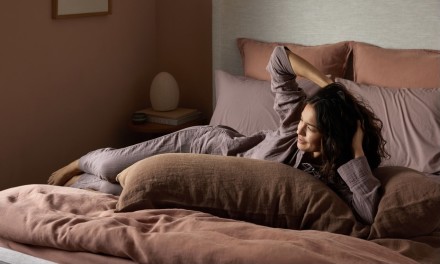 woman laying in bed with linen sheets