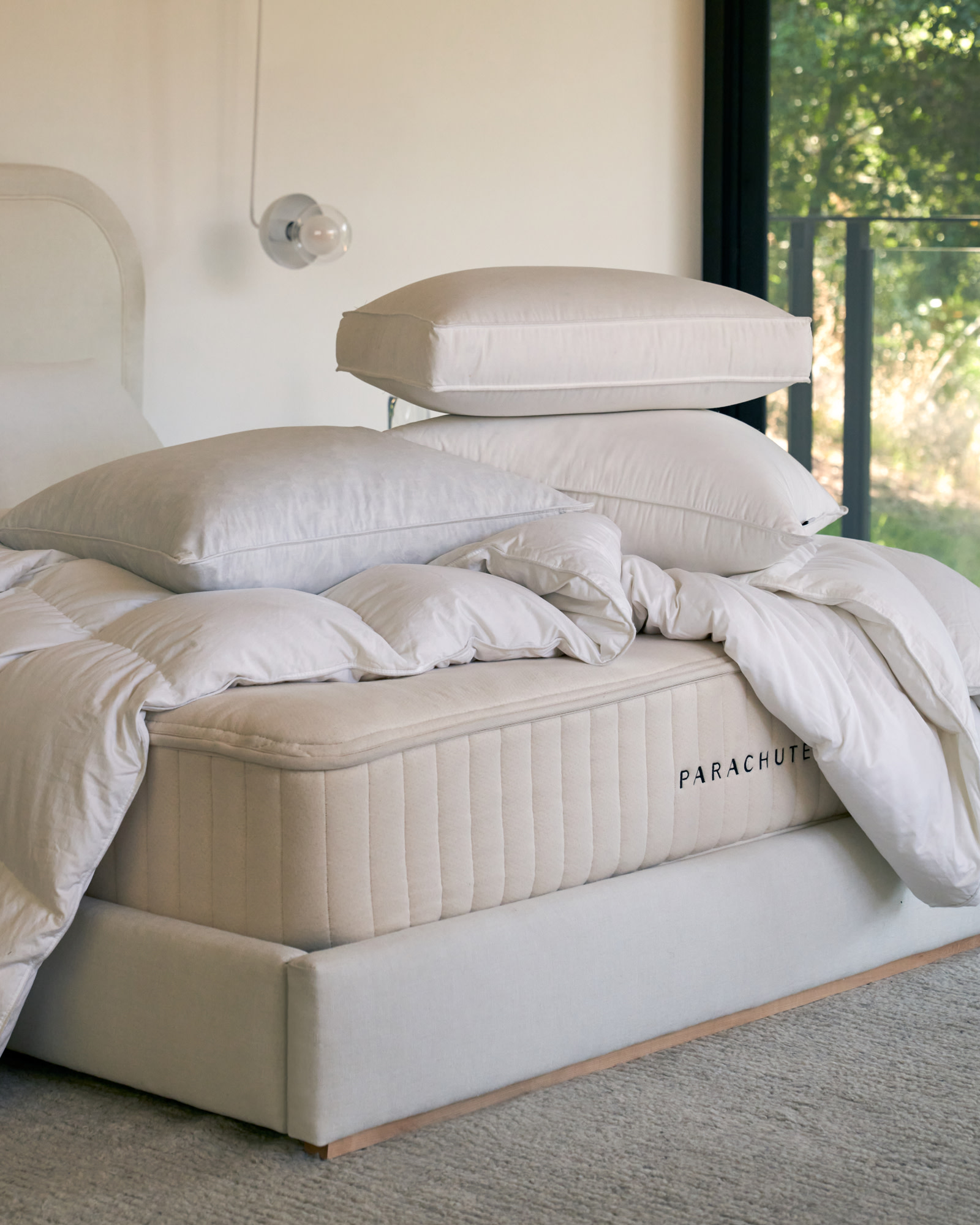 Stack of bare pillow and duvet inserts on a bed