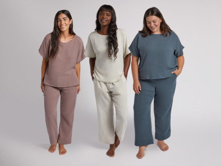 Three women wearing gauze sleepwear in purple, ivory, and blue