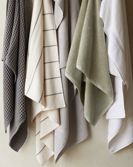 A row of hanging towels in various colors and textures