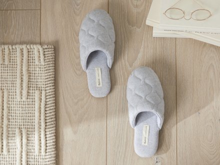 Chambray Quilted Slippers Shown In A Room