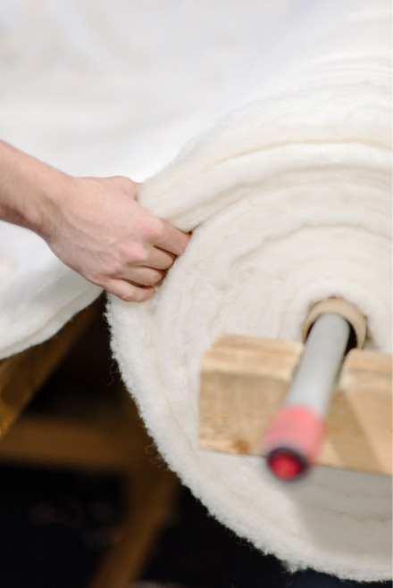 Close up photograph of Parachute employee handling product in factory